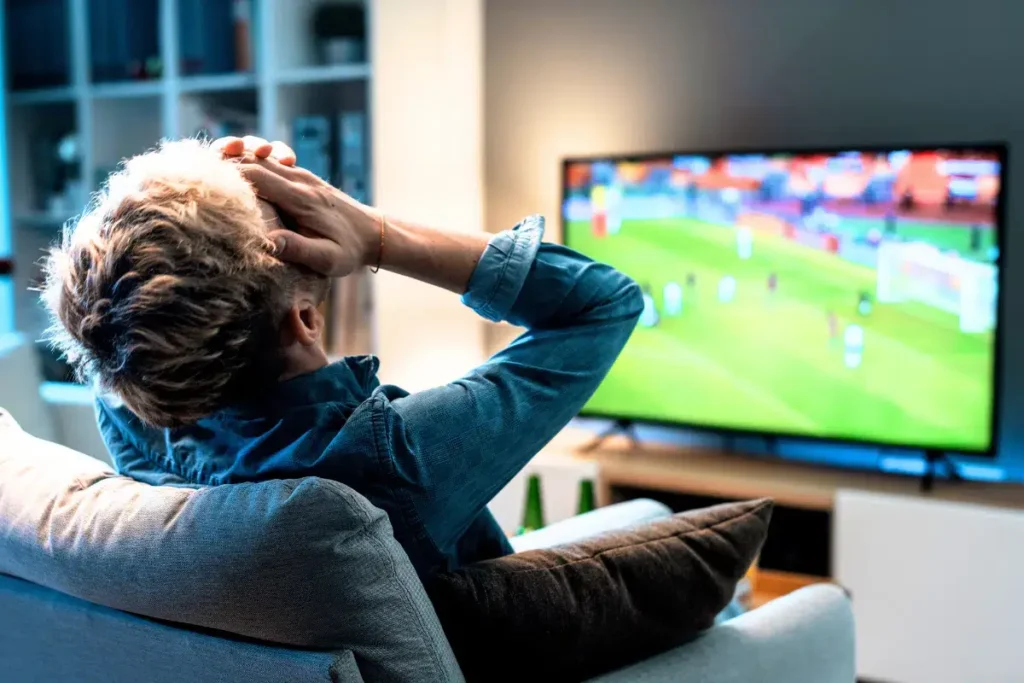 Troubleshooting IPTV DAZN – Mann schaut entspannt Sport auf Smart TV